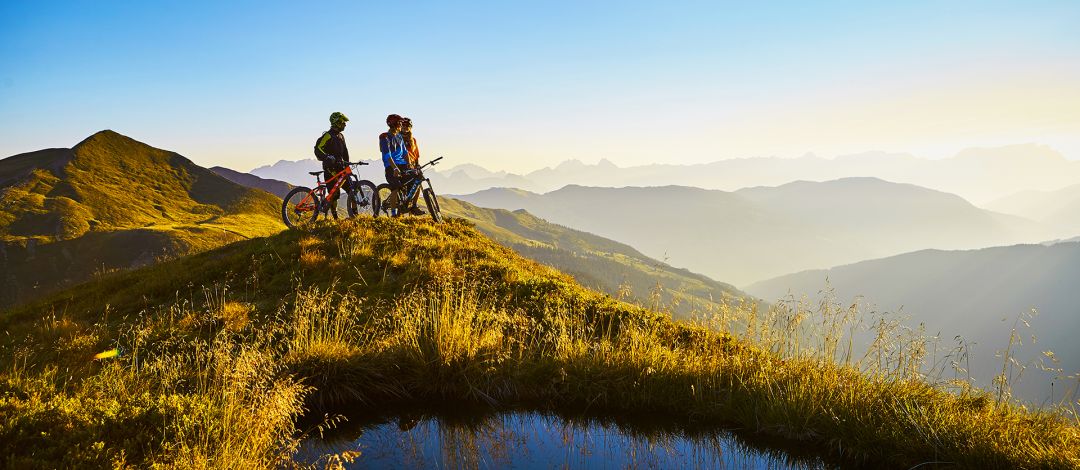 Radfahrer am Gipfel neben einem kleinen See
