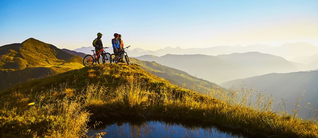 Radfahrer am Gipfel neben einem kleinen See